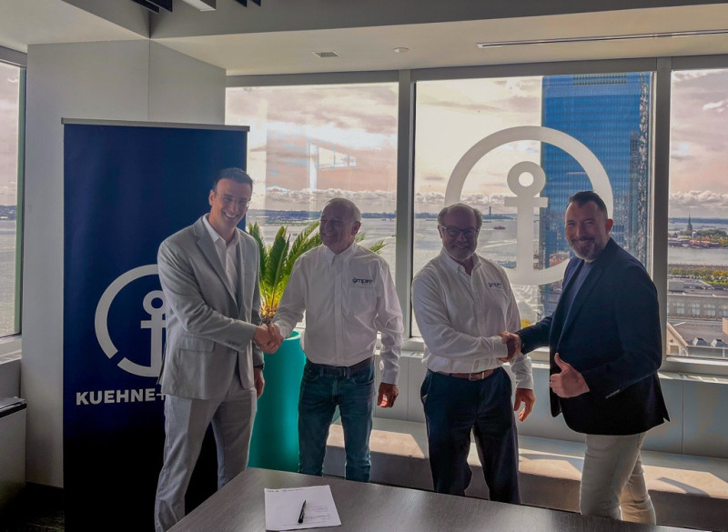 Executives from Empire Energy and Kuehne+Nagel shaking hands at partnership signing ceremony to enhance offshore wind logistics and project delivery.