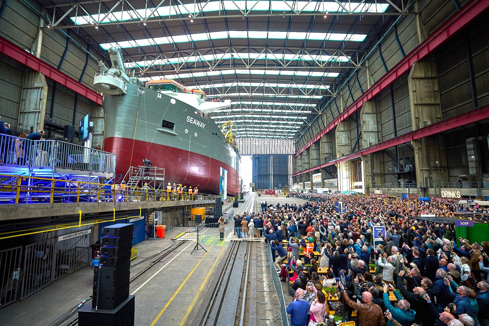 Trailing suction hopper dredger Seaway being launched at Royal IHC shipyard with large crowd attending the ceremony.